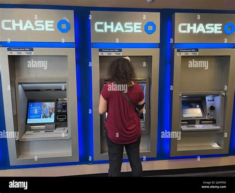 Woman deposits checks and withdraws cash at a Chase ATM in the lobby of ...