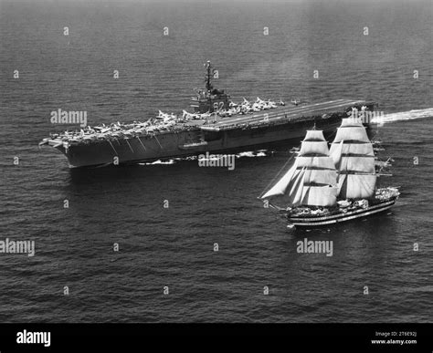 USS Independence (CVA-62) underway with sailing ship Amerigo Vespucci ...
