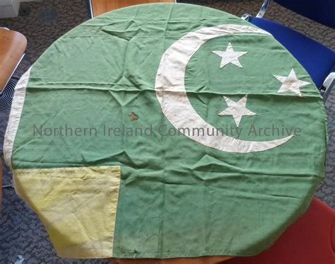 Green flag with cream crescent moon and three stars beside it. Yellow ...