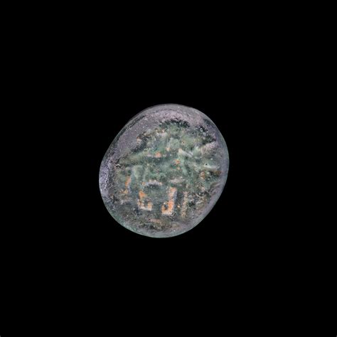 AN EARLY ISLAMIC GLASS WEIGHT OF QUARTER DIRHAM