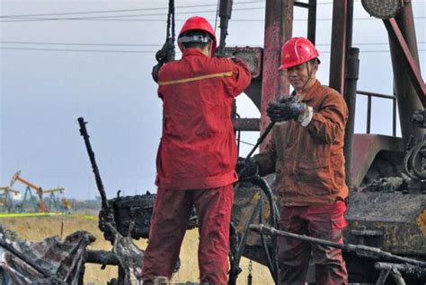油田工人工资工业工人在巨大的石油和天然气炼油厂管道前工作。 石油工业概念。 石油和天然气工作照片-正版商用图片11iqlm-摄图新视界