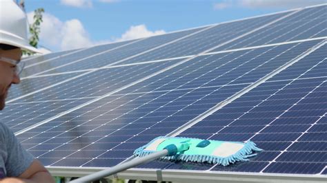 Worker cleans solar panel with water clean at solar power plant ...