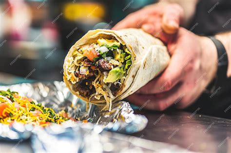 Premium Photo | A hand rolling a burrito tightly to keep the filling inside