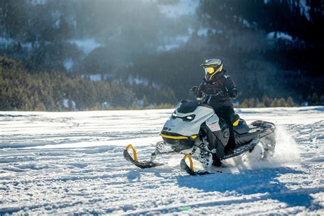 Rider riding up a snowy mountain on the 2027 Ski-Doo Summit