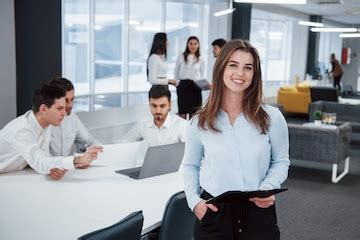 Relaxed woman indoors. portrait of young girl stands in the office with ...