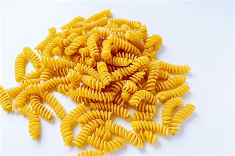 Premium Photo | Pile of spiral pasta scattered on light background ...
