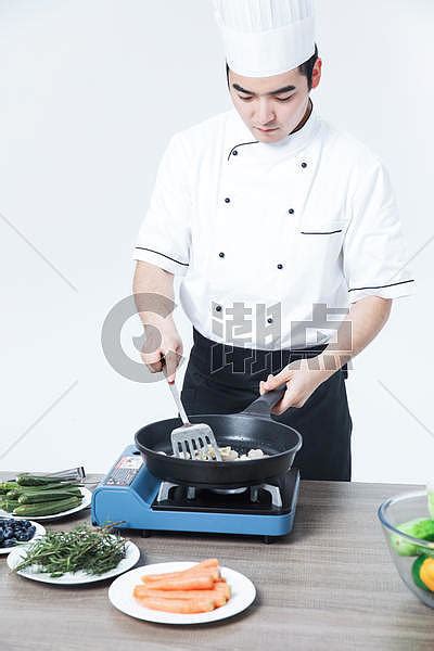 轻的男厨师商业厨房的炒菜厨师炒菜高清图片下载-正版图片300114820-摄图网