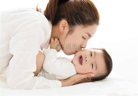年轻的母亲亲吻可爱的宝贝男孩高清图片下载-正版图片502427200-摄图网