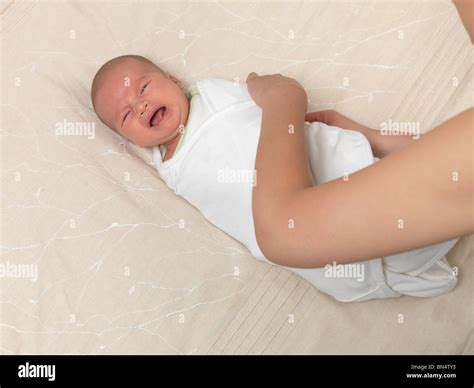 Mother swaddling a crying six week old baby boy Stock Photo - Alamy
