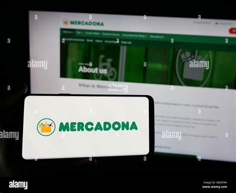 Stuttgart, Germany - 03-06-2025: Person holding smartphone with logo of Spanish supermarket ...