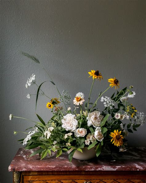 Whimsical flower arrangement with yellow and light colored flowers ...