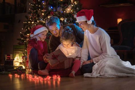 圣诞树下幸福的家庭图片-一个家庭正在打开他们的礼物素材-高清图片-摄影照片-寻图免费打包下载