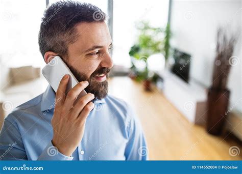 A Man with a Smartphone Making a Phone Call at Home. Stock Photo ...