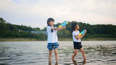 亲子玩水夏季父女河边玩水摄影图配图高清摄影大图-千库网