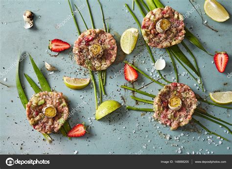 Four portions of raw meat nests with quail eggs, cucumers and st — Stock Photo © PGstudija ...