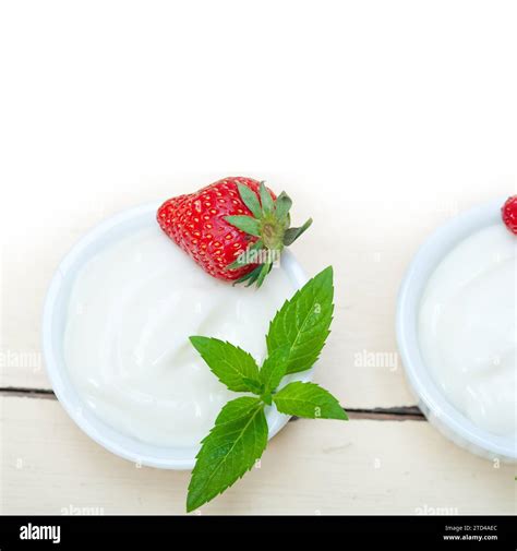 Organic Greek yogurt and strawberry over white rustic wood table Stock ...