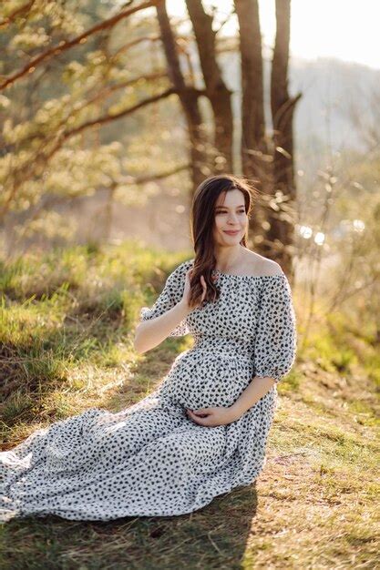 Premium Photo | Young pregnant woman relaxing in park outdoors