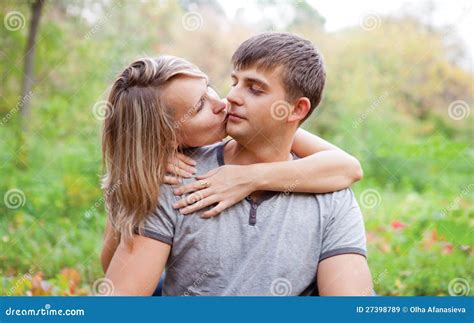 Girl Kiss a Guy on the Cheek. Stock Image - Image of holding, outdoors ...