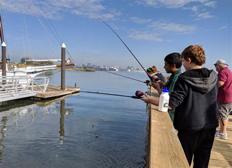 Kids fishing at Masonville Cove pier with Baltimore skyline in ...