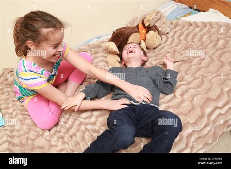 Sister tickling her younger brother Stock Photo - Alamy