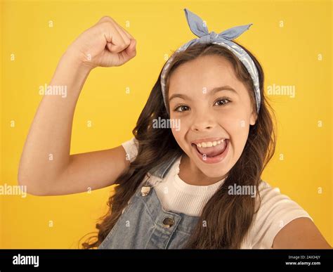 I did it. Happy little girl flex biceps on yellow background. Girls ...
