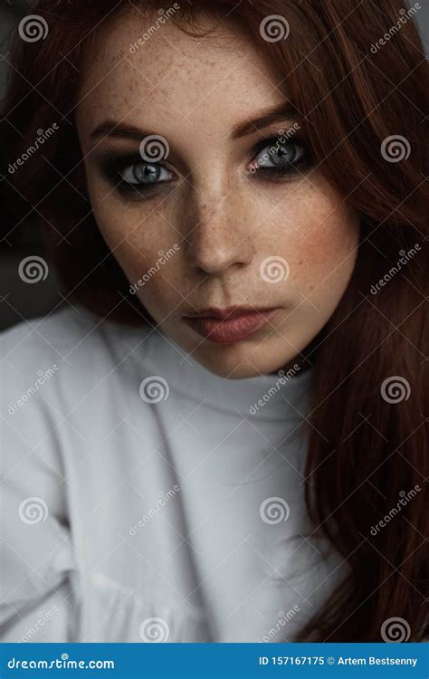 Portrait of a Red-haired Blue-eyed Girl with Dark Eye Makeup Looking at ...
