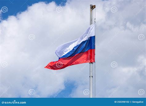 Bandera De Rusia En Un Asta Contra Un Cielo Azul Con Nubes Foto de ...