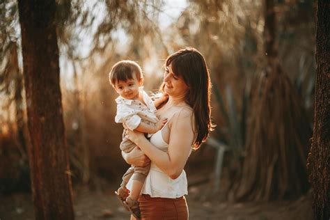A woman holding a baby in the woods · Free Stock Photo