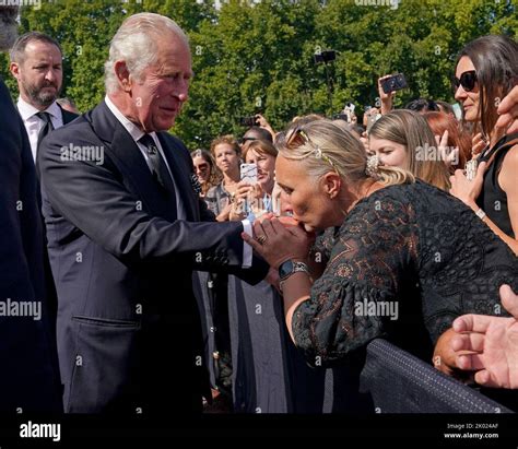 A well-wisher kisses the hand of King Charles III during a walkabout ...