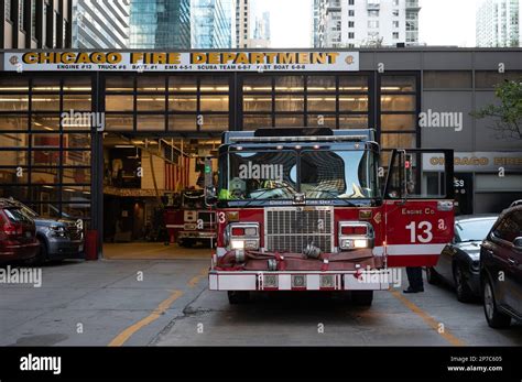 An illuminated red fire truck parked in front of the Chicago Fire ...