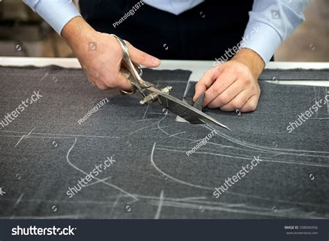 Tailor Cutting Fabric Using Large Scissors Or Shears As He Follows The ...
