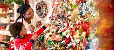Family tradition. Cute little black girl decorating Christmas tree with ...