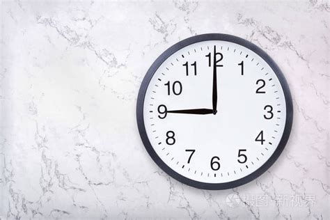 挂钟显示九点钟的白色大理石纹理。办公室时钟显示晚上9点或上午9点照片-正版商用图片2h0eck-摄图新视界