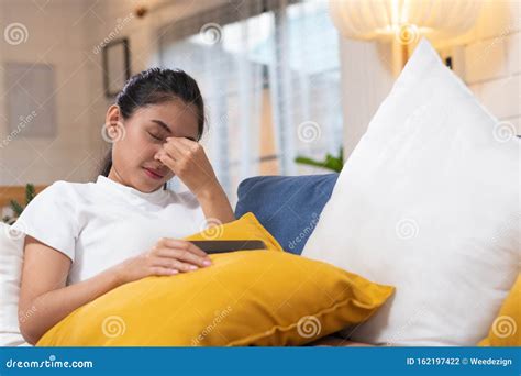 Young Asian Woman Feeling Stress and Closed Eyes Suffering from Headache and Lying Down on Sofa ...