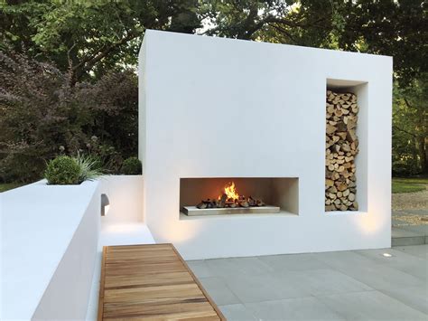 Modern outdoor fire with log store | Modern outdoor fireplace, Outdoor ...