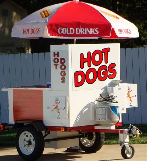 a hot dog cart with an umbrella on top