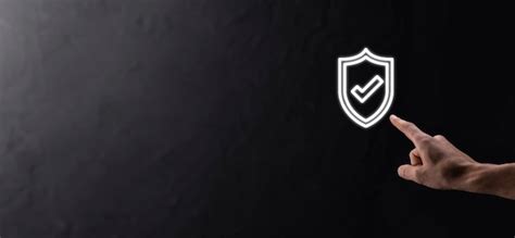 Male hand holding protect shield with a check mark icon on blue ...