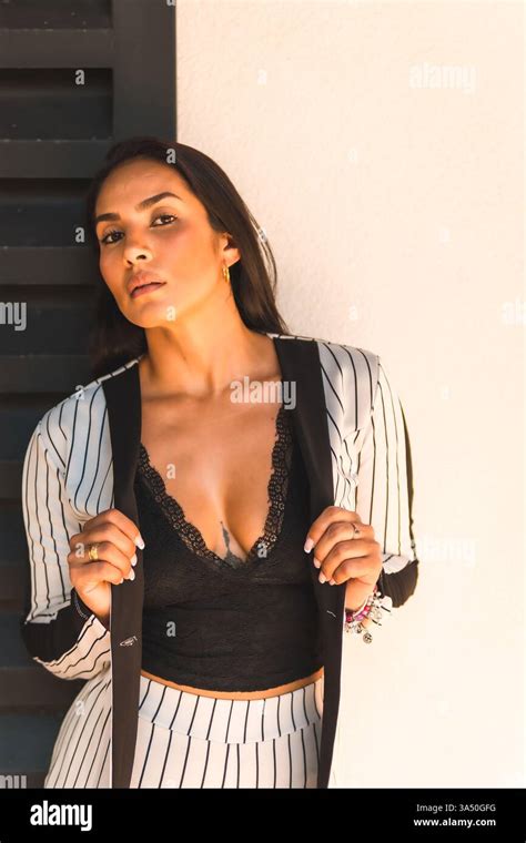 Lifestyle, straight-haired Latin brunette girl in a white suit and ...