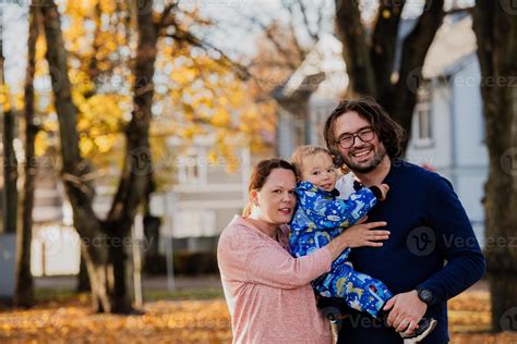 en un soleado otoño día en el parque, un madre y padre cariñosamente ...