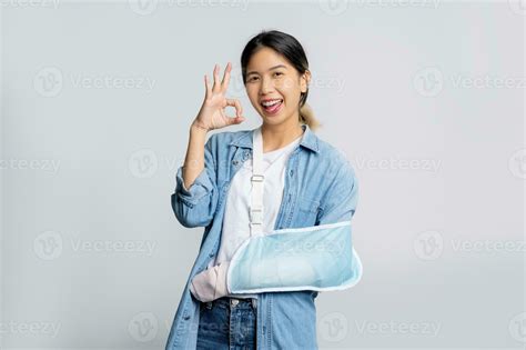 Beautiful Asian office worker wearing blue jeans put on soft splint due ...