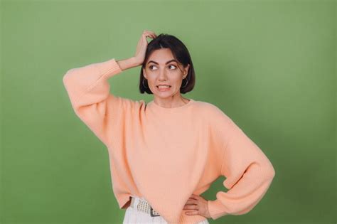 Young stylish woman in casual peach sweater and orange glasses isolated ...