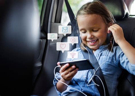 Kleines Mädchen, das ein Telefon in einem Auto benutzt | Kostenlose Foto