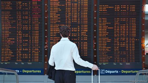 Passengers look at flight delays on a departure board at Orlando International Airport on November 0