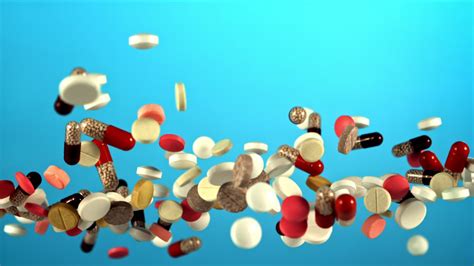 Different types of pills fly up and fall down. On the blue screen. Filmed on a high-speed camera ...