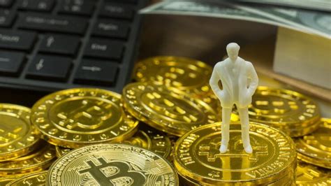 Close-up of golden bitcoins and figurine on table | Premium Photo