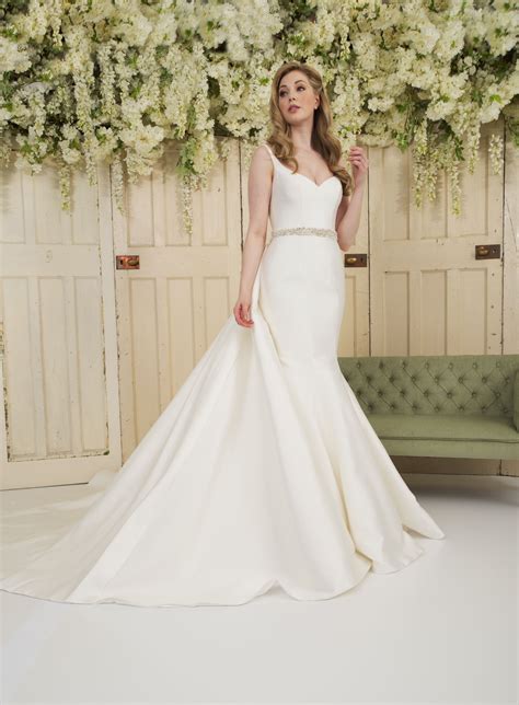 An ivory Mikado fit n flare classic fishtail wedding dress with a contemporary detachable train ...