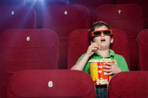 Stock photo 110539901 - Surprised boy eating popcorn in the movie theater