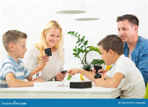 Happy Young Family Playing Card Game at Dining Table at Bright Modern ...