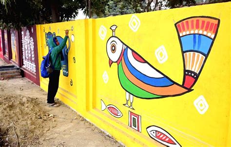 Artists paint a wall with intricate and vibrant scriptures as the part ...