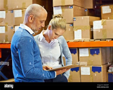 Time for a stocktake. two people doing an inventory check in a warehouse Stock Photo - Alamy